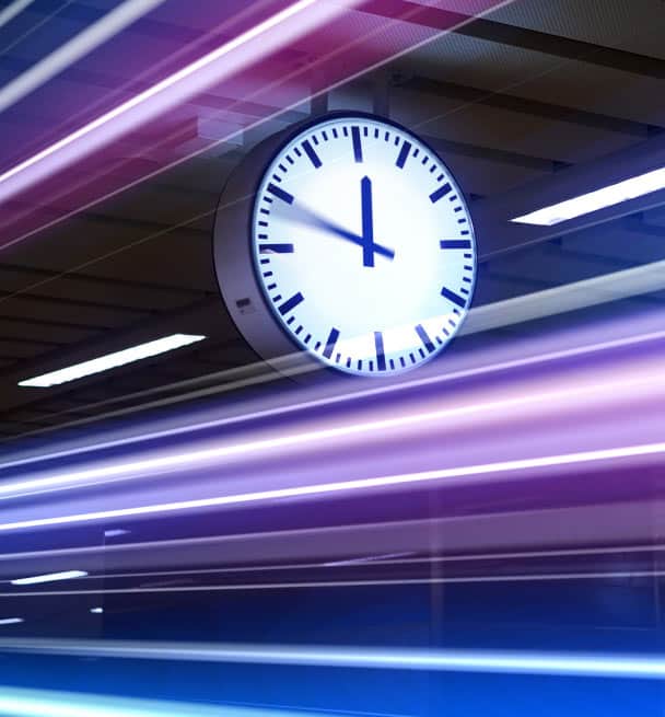 Image of a clock with a very fast train passing by