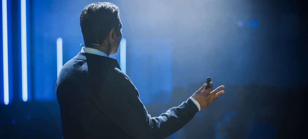 Image of a man addressing investors explaining the benefits of partnering with Qorbis