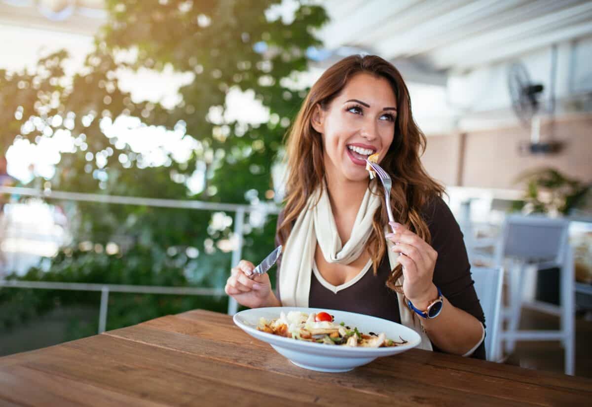 Smiling woman eating a healthy lunch in a luxury restaurant