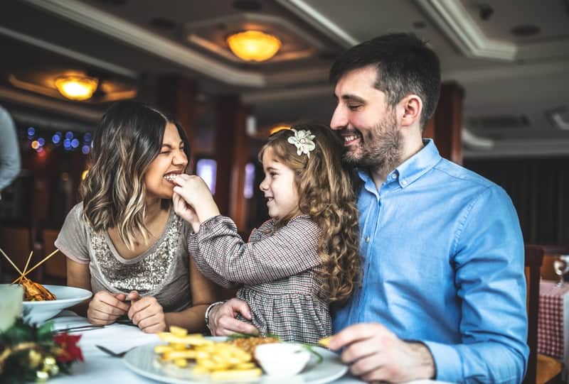 Image of a young family enjoying a meal together