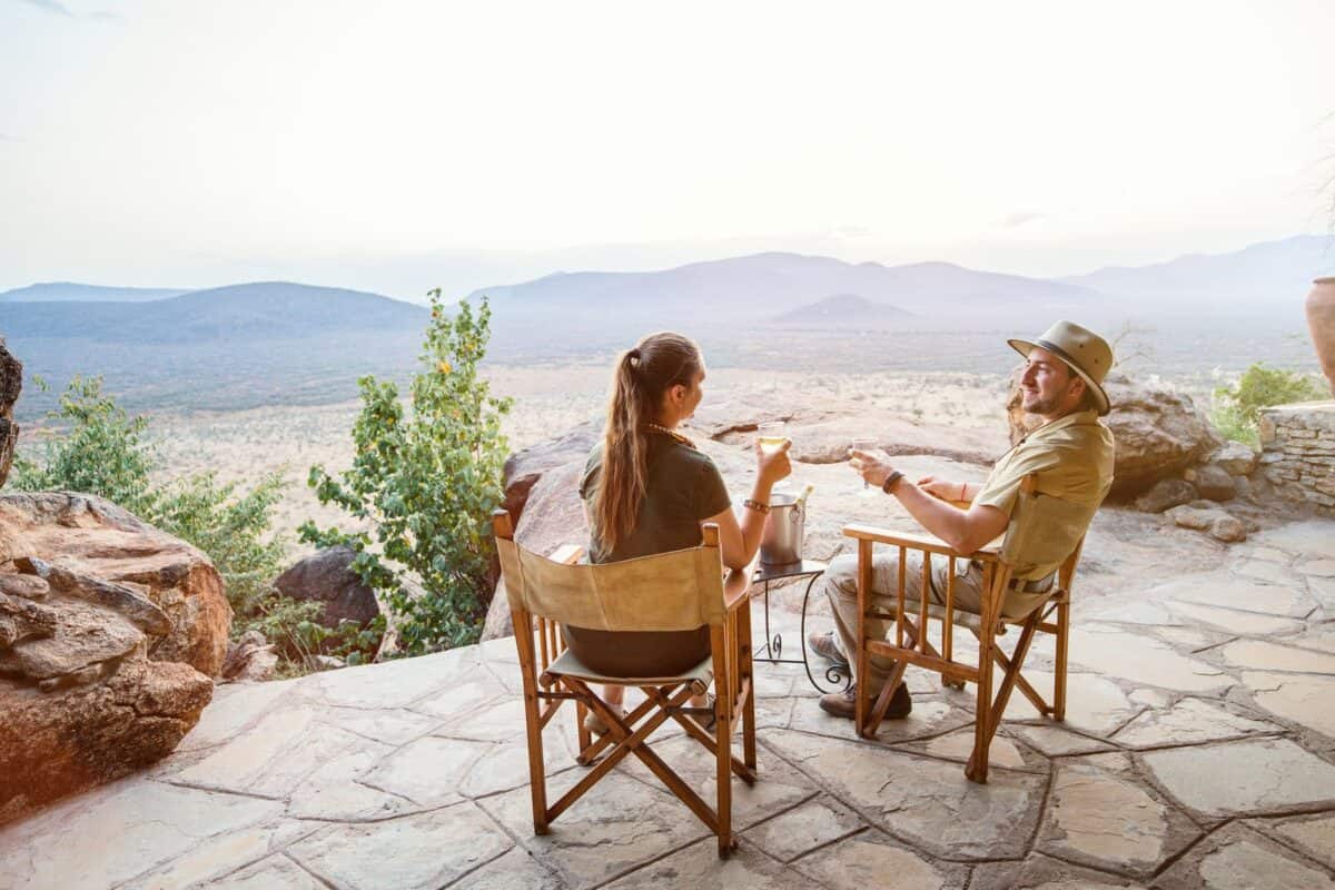 Image of a couple sitting on the patio of a safari lodge